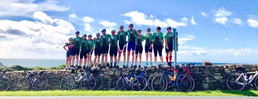 A cycling club lined up along a coastal wall in Ireland